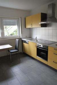 a kitchen with a stove and a table and a window at Gästewohnung Pakulies in Weinheim