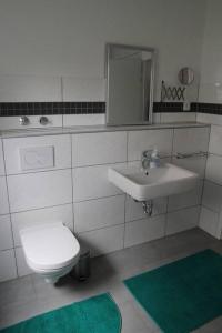 a bathroom with a white toilet and a sink at Gästewohnung Pakulies in Weinheim