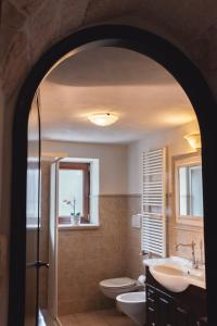 a bathroom with two sinks and a toilet and a window at Masseria Montanaro in Cisternino