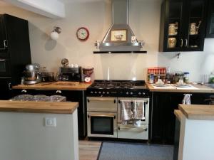 a kitchen with a stove top oven in a kitchen at Relais St Jacques - Roanne in Saint-Haon-le-Châtel
