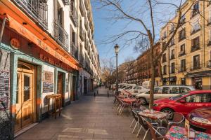 a sidewalk with tables and chairs on a city street at Luminoso Apartamento en Lavapiés-Tirso de Molina in Madrid