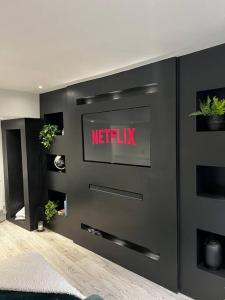 a netflix sign on a wall in a room at Luxe City Hot Tub: Urban Retreat in Norwich