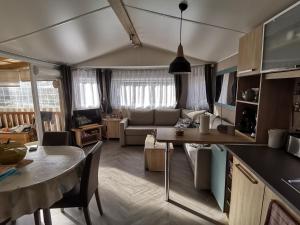 a kitchen and living room with a couch and a table at Bonne anse plage in Les Mathes