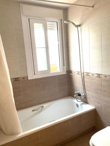 a bath tub in a bathroom with a window at Apartamento San Francisco in Lucena