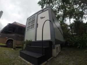 a small trailer sitting next to a van at Tiny House Urban in Balneário Camboriú
