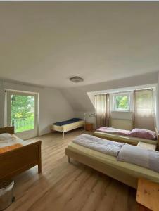 ドルステンにあるHotel Haus Schürmannのベッド2台と窓2つが備わる広いベッドルーム1室が備わります。