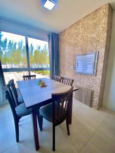 comedor con mesa, sillas y ventana en Residencial Provincia Di Trento Beira Mar, en Torres