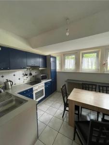 a kitchen with blue cabinets and a table with chairs at Hotel Haus Schürmann in Dorsten