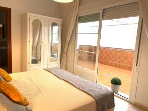 a bedroom with a bed and a large window at Apartamento San Francisco in Lucena