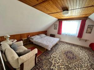 a bedroom with a bed and a couch and a window at Ubytování u Přadků in Čeladná