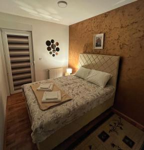 a bedroom with a bed with a tray on it at Apartman Lux in Vranje