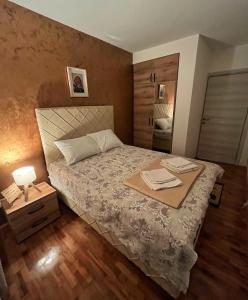 a bedroom with a bed with a tray on it at Apartman Lux in Vranje