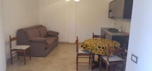 a living room with a couch and a table and chairs at Villa Rosa in Latte