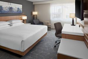 a hotel room with a bed and a desk at Delta Hotels Calgary Airport In-Terminal in Calgary