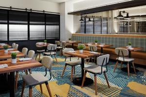 a dining room with wooden tables and chairs at Delta Hotels Calgary Airport In-Terminal in Calgary