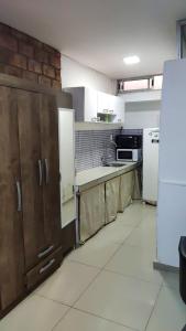 a large kitchen with wooden cabinets and a refrigerator at Sombra in Ciudad de la Costa
