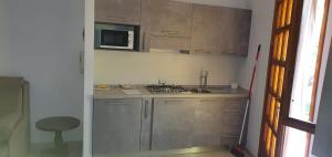 a small kitchen with a stove and a microwave at Villa Rosa in Latte +9 photos