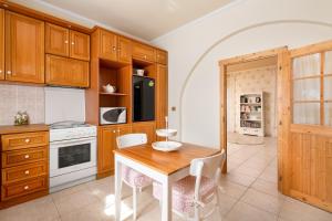 a kitchen with wooden cabinets and a table and chairs at Villa - 1st Floor in Ixia