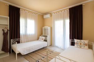 a bedroom with two beds and a window at Villa - 1st Floor in Ixia