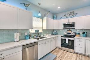 uma cozinha com armários brancos e paredes azuis em Surfside Beach Home with Ocean Views! em Surfside Beach