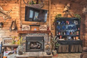 a living room with a television and a fireplace at Missouri Vacation Rental with Fire Pit Access 