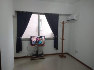 Habitación con TV frente a una ventana en Torre Murano I en Corrientes