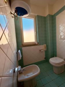 a bathroom with a toilet and a sink and a window at Baia di Talamone in Talamone