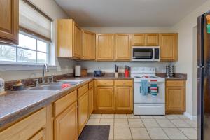 a kitchen with wooden cabinets and a white stove top oven at Charming Biloxi Vacation Rental Near Beach! in Biloxi