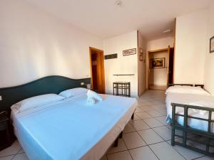 a hotel room with two beds and a hallway at Baia di Talamone in Talamone