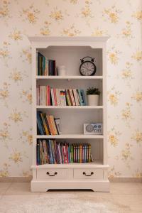 a white book shelf with books and a clock at Villa - 1st Floor in Ixia