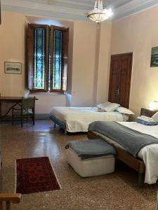 a bedroom with two beds and a table in it at CASA BENVENUTI in Pisa