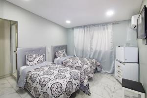 a bedroom with two beds and a dresser at Hotel Señorial in Santo Domingo