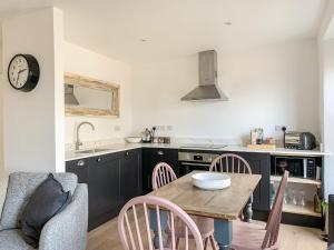a kitchen with a table and chairs and a sink at The Boat Watch - 28477 in Mousehole
