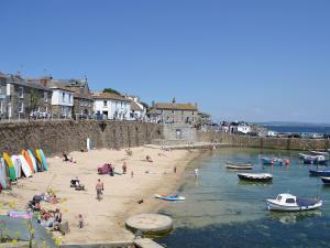 a group of people on a beach with boats in the water at The Boat Watch - 28477 in Mousehole