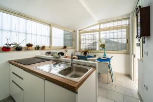 a kitchen with a sink and two windows at Monolocale Gio in Carbonia