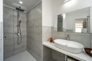 a white bathroom with a sink and a shower at Monolocale Gio in Carbonia