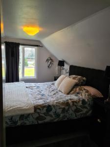 1 Schlafzimmer mit einem Bett mit einem Fenster und einer Tagesdecke in der Unterkunft Tosthult holiday 3 in Lönsboda