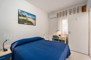 una camera con letto blu e scrivania di Monolocale Gio a Carbonia