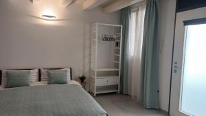 a white bedroom with a bed and a window at Room 28 in Ferrara