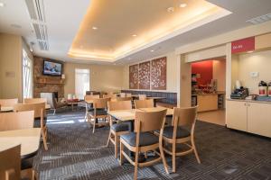 una sala da pranzo con tavoli e sedie e una cucina di TownePlace Suites by Marriott Provo Orem a Orem