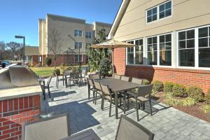 a patio with chairs and a table with an umbrella at Residence Inn by Marriott Woodbridge Edison/Raritan Center in Woodbridge