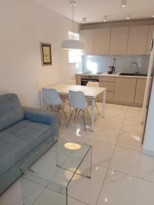 - un salon avec un canapé bleu et une table dans l'établissement Apartman Daria, à Split