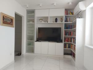 - un salon avec une télévision et des étagères dans l'établissement Apartman Daria, à Split