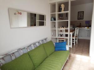 ein Wohnzimmer mit einem grünen Sofa und einer Küche in der Unterkunft Soñar en la Patagonia in Trelew