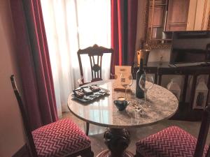 - une table avec deux chaises et une table avec des verres à vin dans l'établissement Apartamentos en pleno centro, Aljibe Rodrigo del Campo 1B, à Grenade