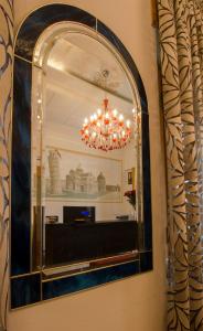 a mirror on a wall with a chandelier at Hotel Maria in Pisa