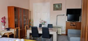 a living room with a table and chairs and a television at Oroszlán Apartman in Szeged