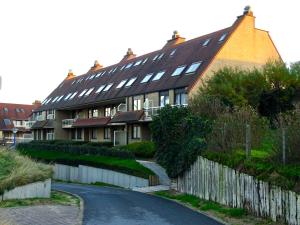 une grande maison avec une route devant elle dans l'établissement Seastar, à Saint-Idesbald