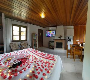 Un dormitorio con una cama grande con flores rojas. en Chalés Leopoldo em Monte Verde en Monte Verde