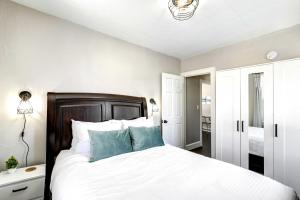 a bedroom with a bed with white sheets and blue pillows at Rochester Vacation Rental about 1 Mi to Downtown in Rochester